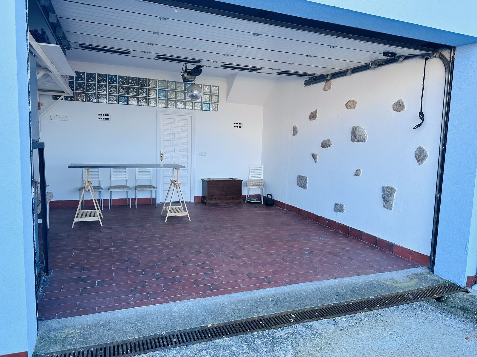 The garage studio with its big door open to the yard, framed in blue.