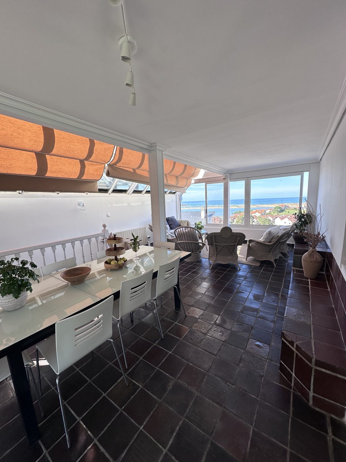 The long dining table on the glazed terrace, with a view out to the sea.
